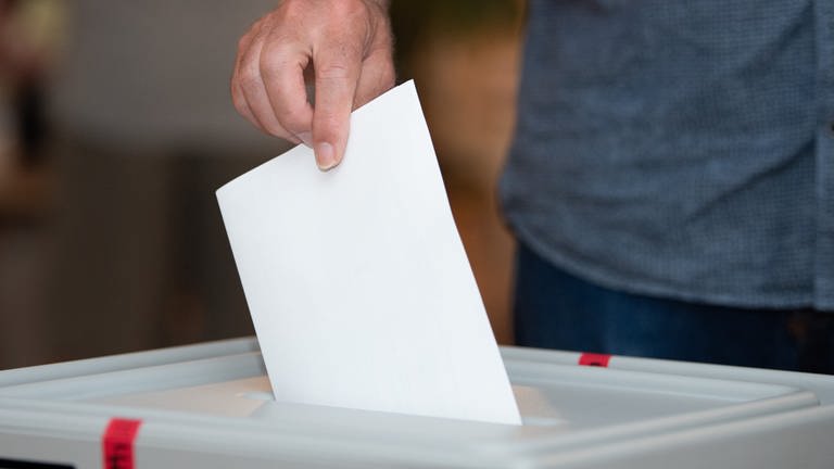 Ein Mann wirft einen Stimmzettel in eine Urne. (Foto: picture-alliance / Reportdienste, Sebastian Kahnert)