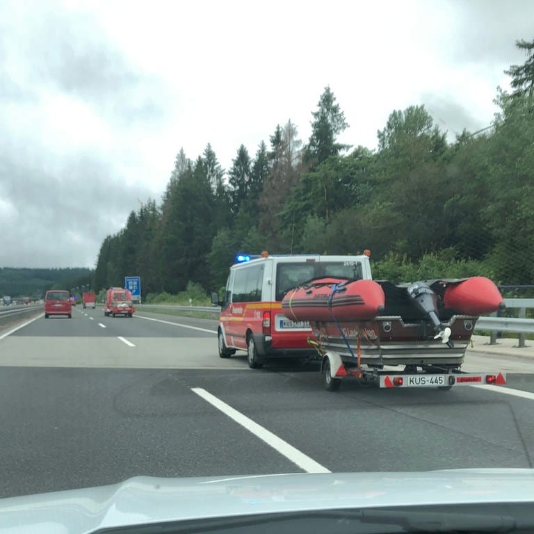 Feuerwehrfahrzeuge mit anhängenden Booten auf der Autobahn
