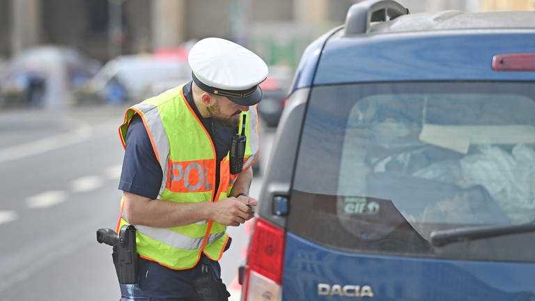Ein Polizist kontrolliert einen Autofahrer auf dessen Fahrtüchtigkeit (Foto: picture-alliance / Reportdienste, picture alliance / SVEN SIMON | Frank Hoermann / SVEN SIMON)