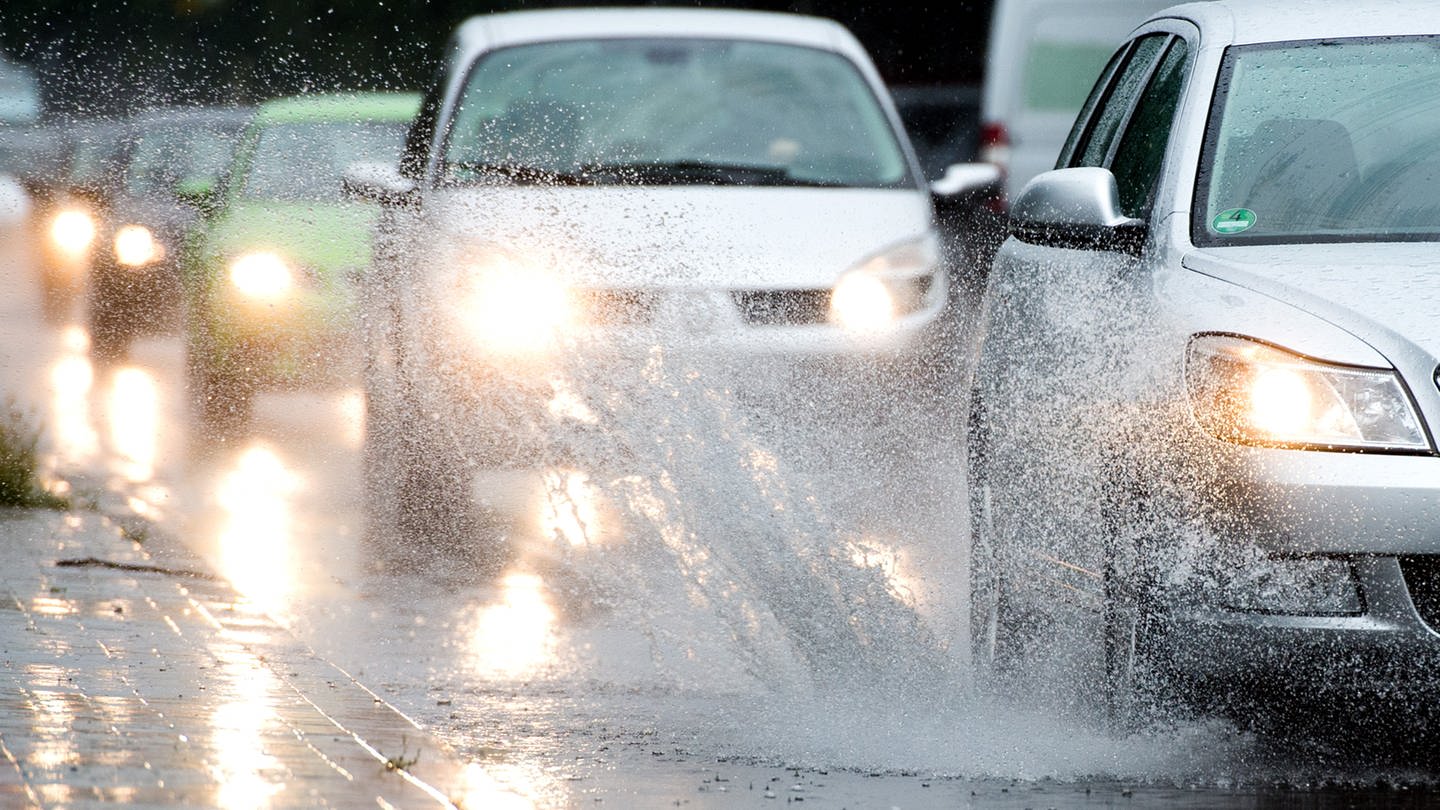 Autos fahren bei starken Regen durch Pfützen auf einer Straße (Foto: picture-alliance / Reportdienste, picture alliance / dpa | Julian Stratenschulte)