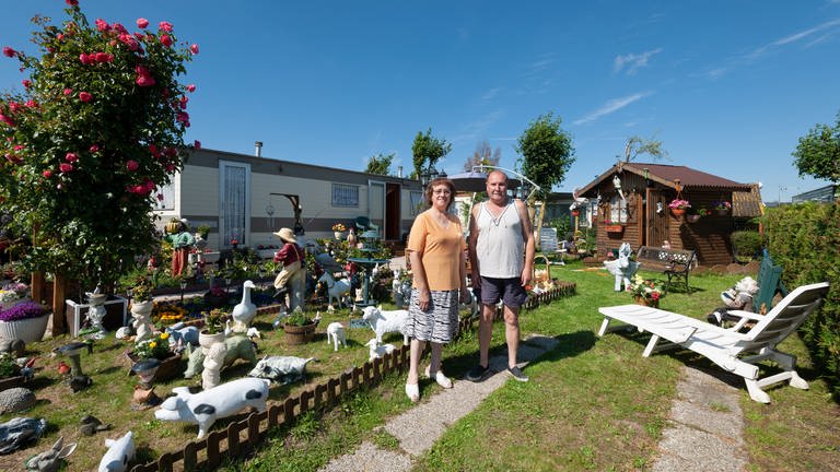 Älteres Ehepaar steht mit vielen kitschigen Skulpturen im Garten  (Foto: SWR, Fotograf: Alain Breyer)