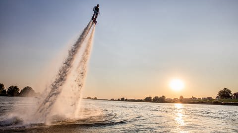 Mensch schießt vor einem Sonnenuntergang mit einem Flyboard aus dem Wasser (Foto: SWR, Fotograf: Jindřich Štreit)