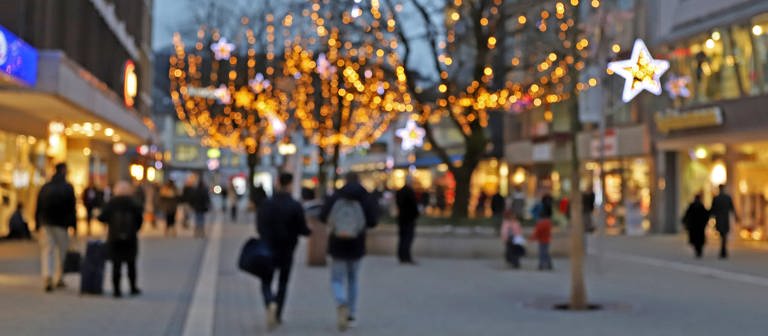Menschen gehen in der Vorweihnachtszeit in einer Fußgängerzone einkaufen. (Foto: IMAGO / Rene Traut)