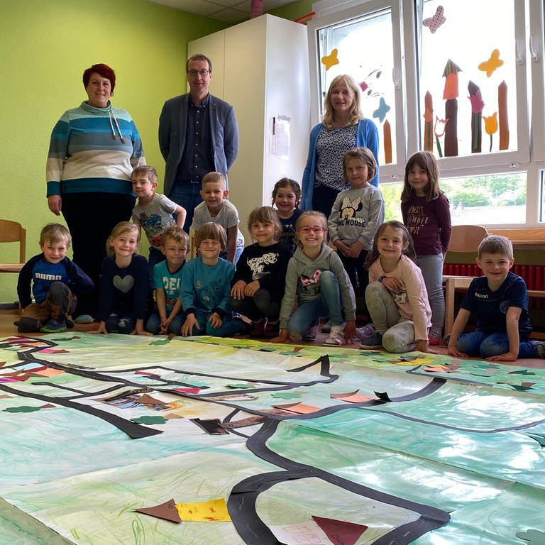 Die Kinder der KITA Waldwichtel in Mölschbach, einem Stadtteil von Kaiserslautern, haben ein großes Plakat von Mölschbach gestaltet. (Foto: SWR)
