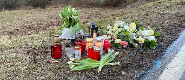 Nach dem Polizistenmord von Kusel liegen am Tatort Blumen und Kerzen am Straßenrand. (Foto: SWR)