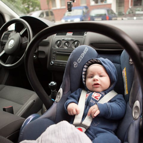 Ein Baby sitzt in einer Babyschale auf dem Beifahrersitz eines Autos. (Symbolbild) (Foto: picture-alliance / Reportdienste, picture alliance / dpa Themendienst | Silvia Marks)