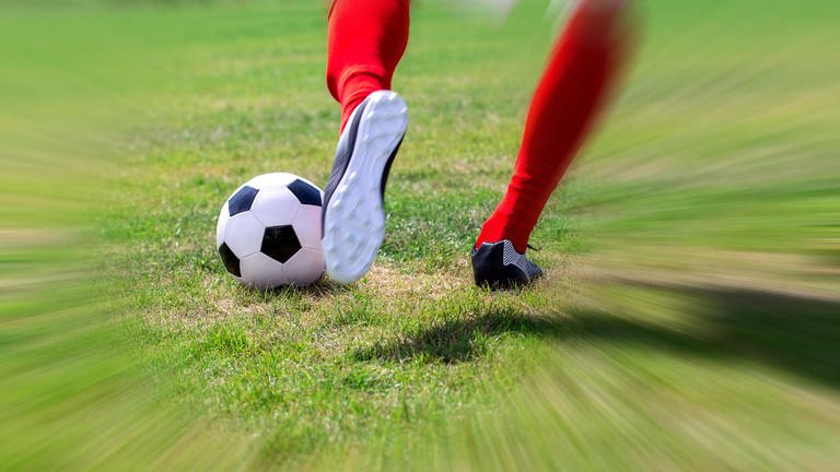 Fußballer mit roten Stutzen schießt einen Ball (Symbolbild) (Foto: picture-alliance / Reportdienste, picture alliance / CHROMORANGE | Udo Herrmann)