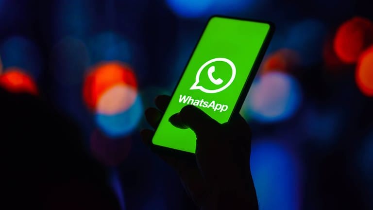 Das Logo von WhatsApp ist auf dem Display eines Smartphones zu sehen.