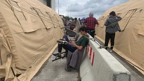 Auf der Airbase in Ramstein sitzen Flüchtlinge aus Afghanistan in der Zeltstadt.  (Foto: SWR)