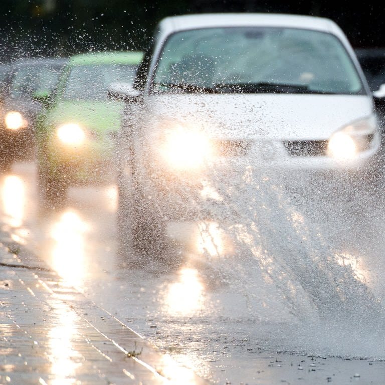 Autos fahren bei starken Regen durch Pfützen auf einer Straße (Foto: picture-alliance / Reportdienste, picture alliance / dpa | Julian Stratenschulte)