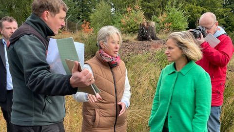 Landrätin der Südwestpfalz,Susanne Ganster, und die rheinland-pfälzische Umweltministerin Katrin Eder schauen sich Pläne vom ehemaligen Militärgelände auf dem Langerkopf an.  (Foto: SWR)