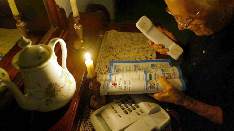 Eine ältere Frau während eines Stromausfalls. (Symbolbild)