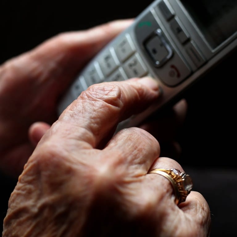 Frau hält Telefon in der Hand - Schockanrufe angeblich aus Krankenhaus Pirmasens