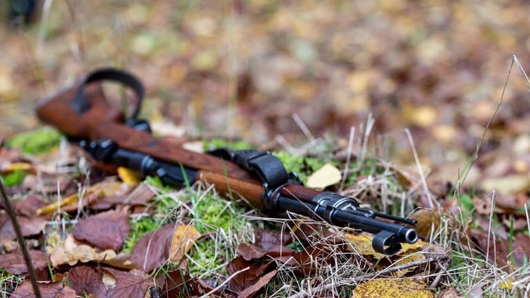 Das Gewehr eines Jägers liegt im Wald auf dem Boden (Foto: picture-alliance / Reportdienste, picture alliance / Fotostand | Fotostand / K. Schmitt)