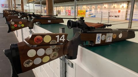 Etliche Luftgewehre- und Pistolen liegen am Schießstand fürs Ostereierschießen bereit.  (Foto: SWR)