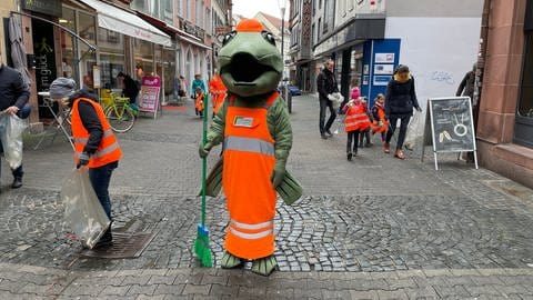 Kinder und das Maskottchen der Stadtbildpflege räumen in Kaiserslautern auf (Foto: SWR)