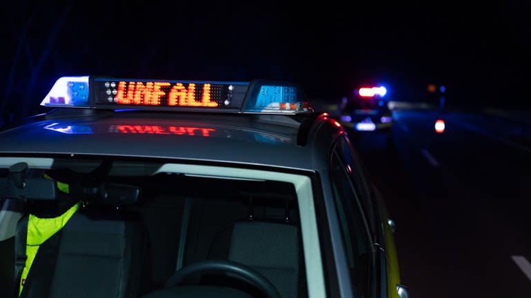 Ein Einsatzfahrzeug der Polizei mit Blaulicht und dem Schriftzug Unfall im Display.