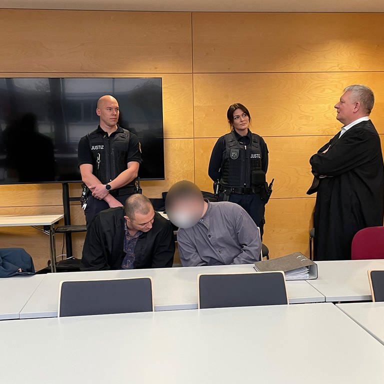 Am Landgericht Kaiserslautern spricht der Hauptangeklagte im Prozess um den Polizistenmord von Kusel mit seinem Verteidiger. 