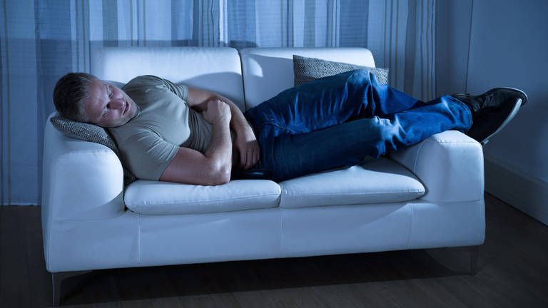 Ein Mann schläft auf einer Couch (Foto: IMAGO, Panthermedia)