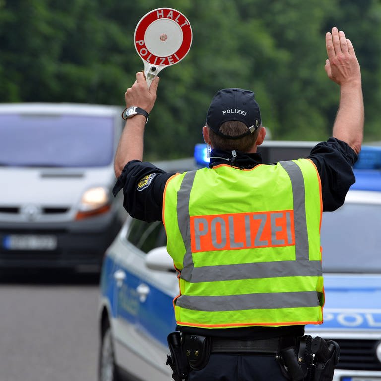 Ein Polizist hält ein Auto an: Die Polizei im Westen der Pfalz hat mehr als 500 Autofahrer auf Alkohol und Drogen kontrolliert. Dabei wurden diverse Verstöße festgestellt. (Foto: picture-alliance / Reportdienste, picture alliance / dpa | Harald Tittel)