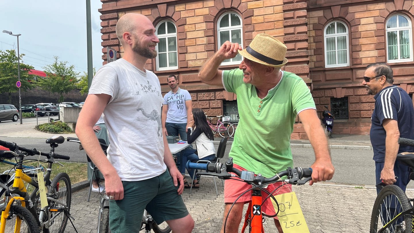 Philip (l.) und sein Vater Daniel (r.) aus Kaiserslautern sind zur Auktion gekommen, um ein Schnäppchen zu machen. Am Ende verlassen sie die Polizei-Auktion aber aber ohne ein Fahrrad. (Foto: SWR)