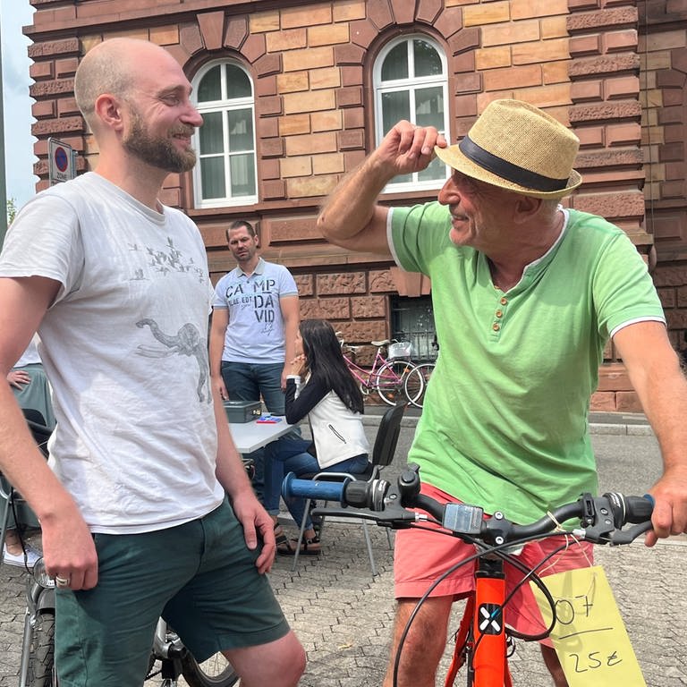 Philip (l.) und sein Vater Daniel (r.) aus Kaiserslautern sind zur Auktion gekommen, um ein Schnäppchen zu machen. Am Ende verlassen sie die Polizei-Auktion aber aber ohne ein Fahrrad. (Foto: SWR)