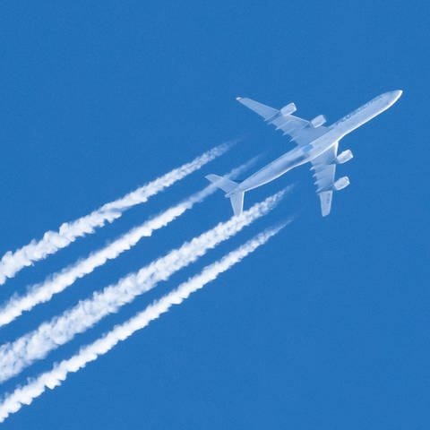 Ein Flugzeug fliegt am Himmel und hinterlässt Kondensstreifen