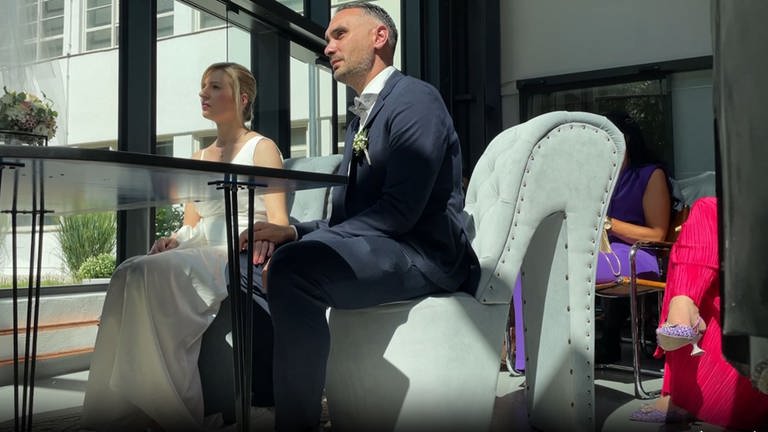 Auf Pumps getraut: Das Brautpaar sitzt auf Stühlen, die wie Schuhe mit Absätzen aussehen.
