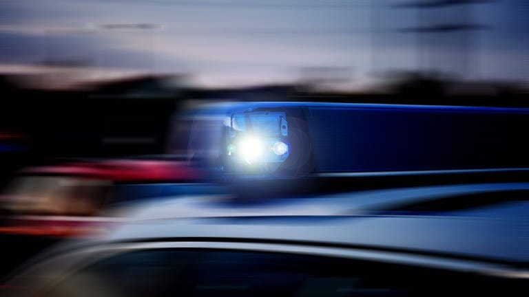 Verwackeltes Blaulicht auf einem schnellfahrenden Polizeifahrzeug im Einsatz.  (Foto: IMAGO, Fotostand)