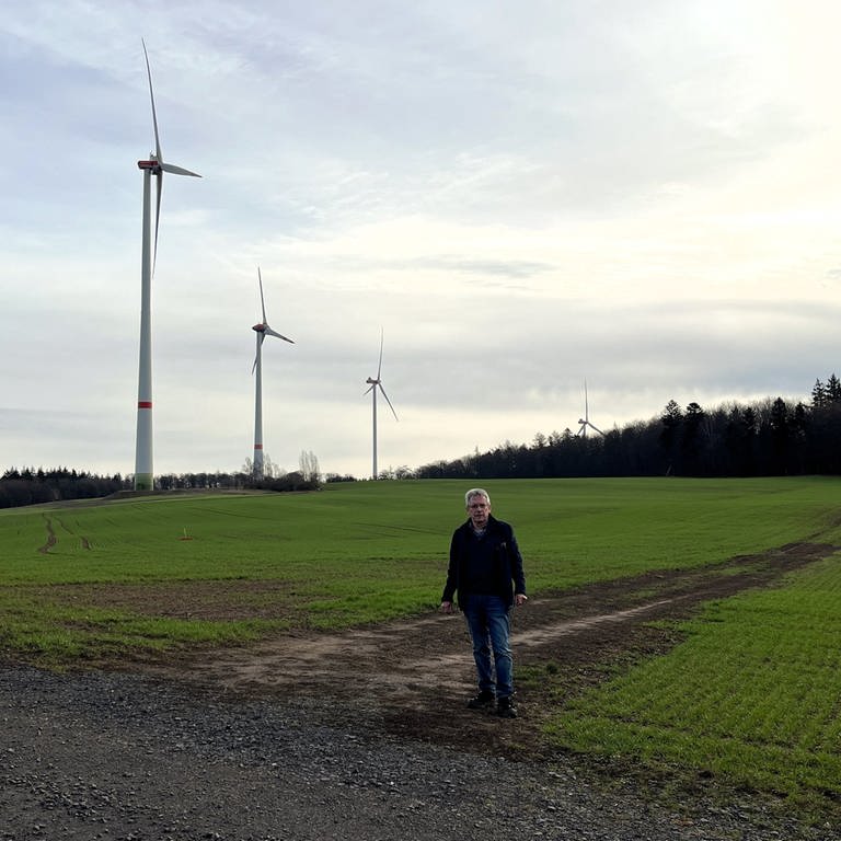 Bürgermeister Albert Ziegler (SPD) steht vor einigen Windrädern seiner Gemeinde Kriegsfeld im Donnersbergkreis. Hier wurden einige der ersten Windräder im Land errichtet. (Foto: SWR)