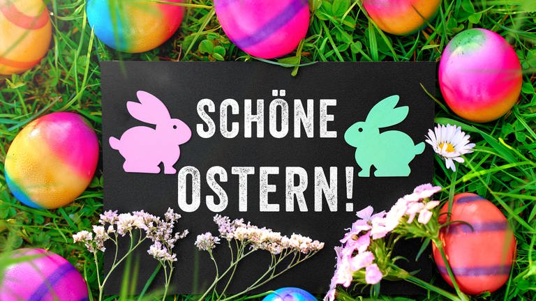 Ostergruß: Schöne Ostern! Auf einem Schild in einer Wiese mit bunten Ostereiern.