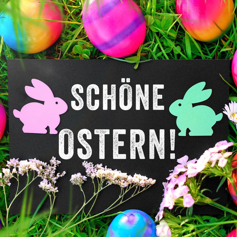 Ostergruß: Schöne Ostern! Auf einem Schild in einer Wiese mit bunten Ostereiern. (Foto: dpa Bildfunk, picture alliance / CHROMORANGE | Michael Bihlmayer)