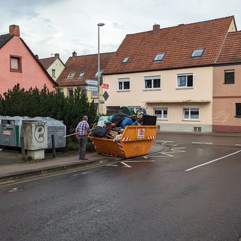 Nach dem Hochwasser hat in Zweibrücken das Aufräumen begonnen. Überall im Stadtgebiet werfen Menschen ihren Müll in die bereitgestellten Container. (Bildquelle: SWR)