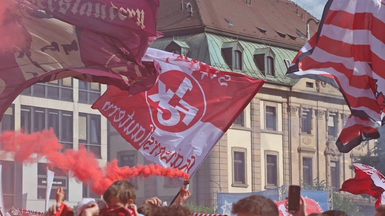 FCK-Fans stehen auf dem Stiftsplatz in Kaiserslautern und schwenken FCK Fahnen, IMAGOHübner