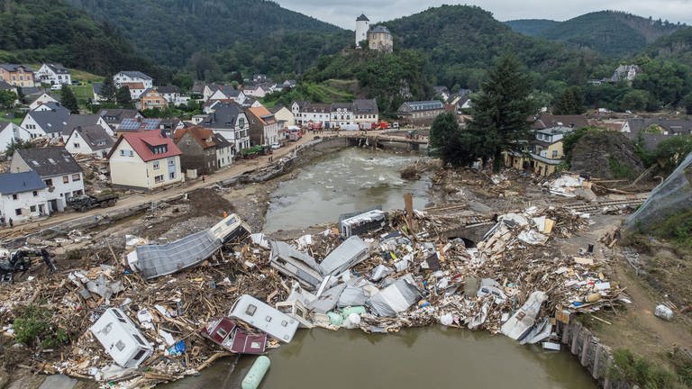 Meterhoch türmen sich Wohnwagen, Gastanks, Bäume und Schrott an einer Brücke über die Ahr (Luftaufnahme mit einer Drohne). Zahlreiche Häuser in dem Ort wurden komplett zerstört oder stark beschädigt, es gibt zahlreiche Todesopfer.  (Foto: picture-alliance / Reportdienste, dpa Bildfunk, Boris Roessler)