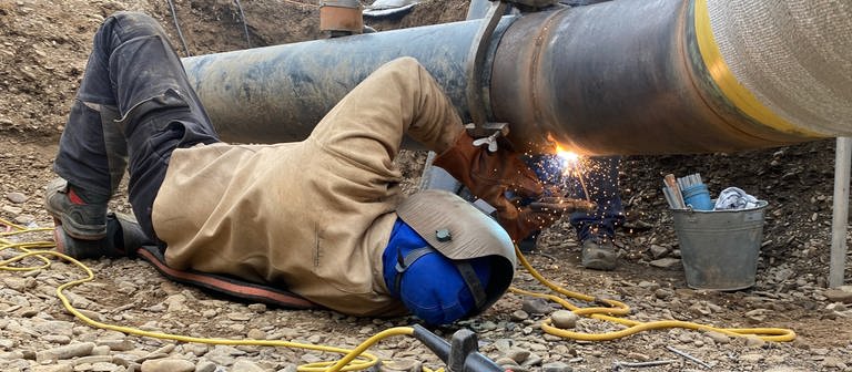 Ein Mitarbeiter des Energieversorgers EVM testet nach der Flutkatastrophe in Bad Neuenahr-Ahrweiler mit Probebohrungen unter der Ahr, ob dort neue Gasleitungen verlegt werden können. (Foto: SWR, Christian Giese-Kessler)