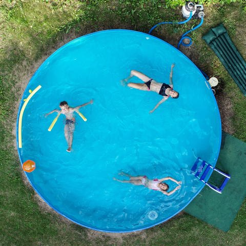 Kinder schwimmen in einem großen mobilen Gartenpool  (Foto: picture-alliance / Reportdienste, Picture Alliance)
