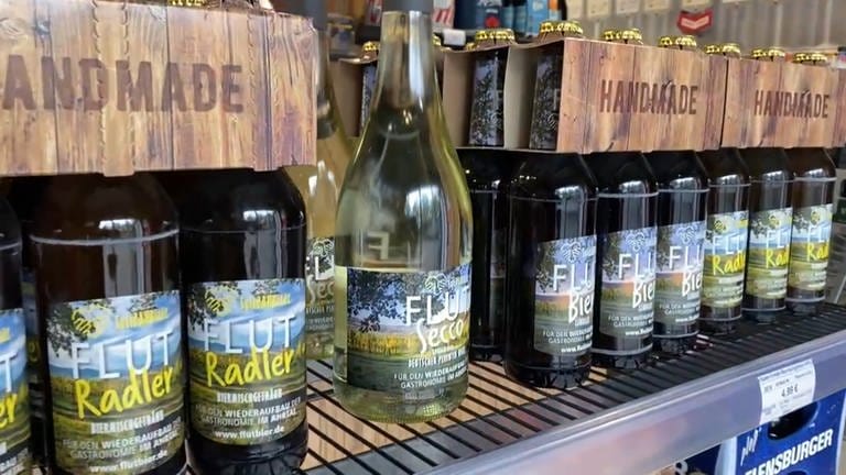 In einem Getränkehandel stehen Bierflaschen und Sekt mit dem Etikett "Flutbier" (Foto: SWR)