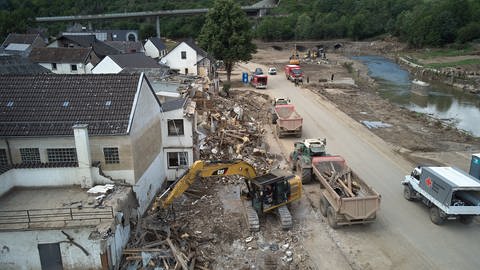 Ein Bagger reißt in Altenburg in der Verbandsgemeinde Altenahr Häuser ab, die durch die Flutkatastrophe zerstört wurde  (Foto: picture-alliance / Reportdienste, picture alliance/dpa | Thomas Frey)