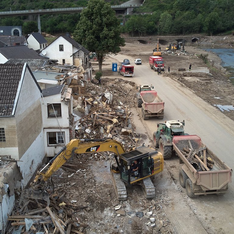 Ein Bagger reißt in Altenburg in der Verbandsgemeinde Altenahr Häuser ab, die durch die Flutkatastrophe zerstört wurde 