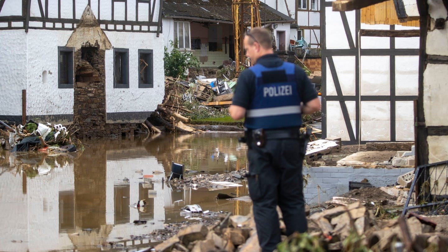Ein Polizist macht sich ein Bild von der Lage im zerstörten Ort Schuld in der Eifel.