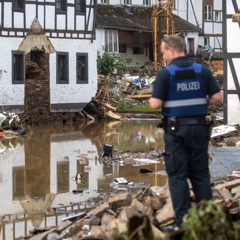 Ein Polizist macht sich ein Bild von der Lage im zerstörten Ort Schuld in der Eifel. (Foto: dpa Bildfunk, Picture Alliance)