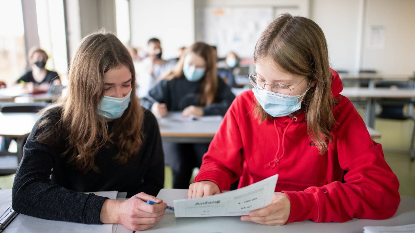 Schülerinnen nehmen mit Mund- und Nasenschutz am Unterricht teil. (Foto: dpa Bildfunk, picture alliance/dpa | Matthias Balk)