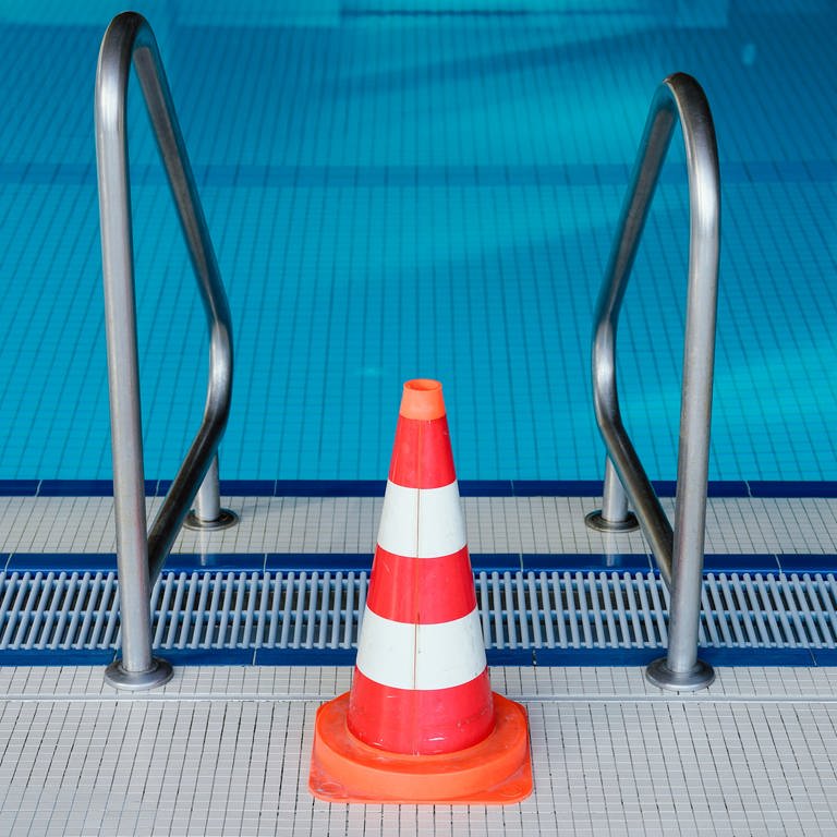 Eine Pylone steht in einem Hallenbad an einer Leiter des Schwimmerbeckens. Das Schwimmbad ist wegen der Coronakrise bis auf weiteres geschlossen.  (Foto: picture-alliance / Reportdienste, Picture Alliance)