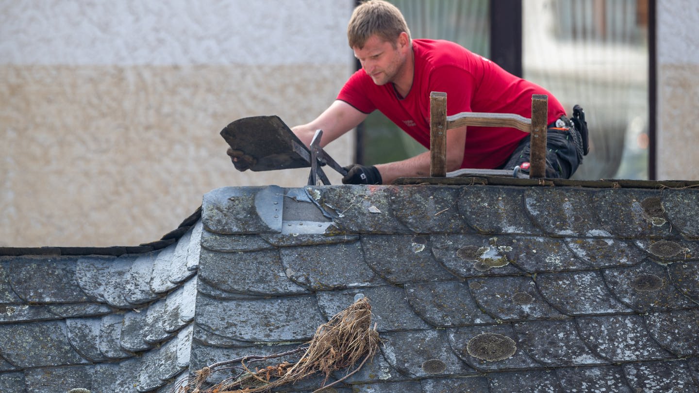 Ein Dachdecker arbeitet an einem der Häuser, die von der Flutkatastrophe beschädigt wurden