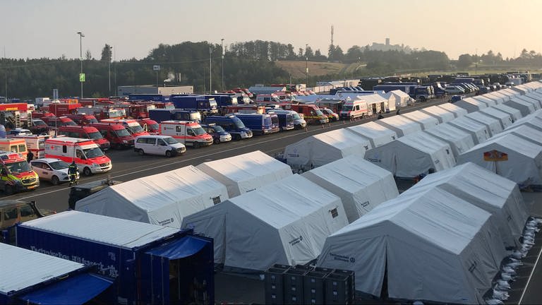 Einsatzfahrzeuge und Zelte auf dem Nürburgring. (Foto: SWR)
