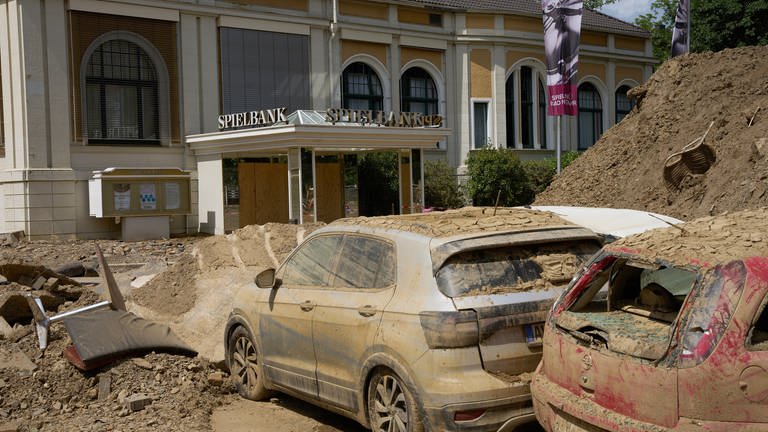 Die Spielbank Bad Neuenahr und zwei völlig verschlammte Autowracks, die durch die Flutkatastrophe verwüstet wurden.  (Foto: picture-alliance / Reportdienste, Picture Alliance)