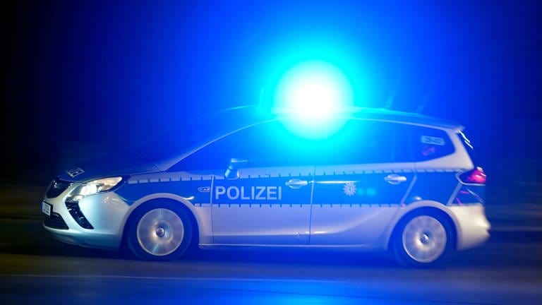 Ein Polizeiwagen mit Blaulicht auf einer nächtlichen Einsatzfahrt (Foto: picture-alliance / Reportdienste, Picture Alliance)