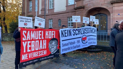 Vor dem Gerichtsgebäude haben die Antifa und die Gruppe "Aktion 3. Welt Saar" mit Plakaten und Transparenten für eine umfassende Aufklärung des Falls demonstriert. (Foto: SWR)
