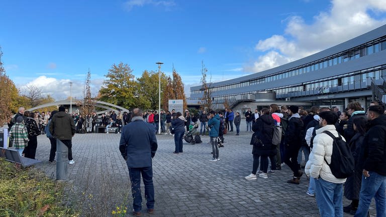 Studierende und Hochschulmitarbeiter stehen auf dem Gelände der Hochschule Koblenz und demonstrieren gegen den geplanten digitalen Lehrbetrieb als Maßnahme zum Energiesparen. (Foto: SWR)